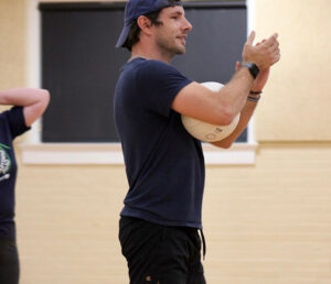 Man clapping while holding a volleyball.