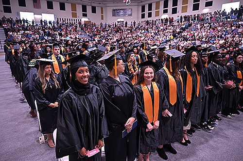 Graduates standing at ceremony.