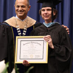 President Cochran presents honorary degree to registrar.