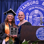 President Cochran presents award to student.