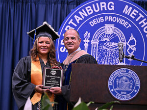 President Cochran presents award to student.
