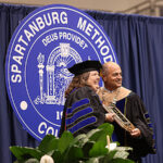 President Cochran presents award to faculty member.