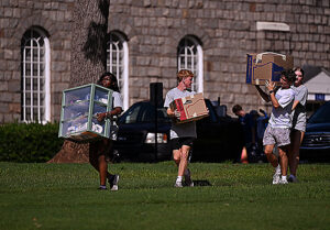 Students moving boxes across campus.
