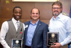 President Scott Cochran presenting awards to two male alumni during Homecoming