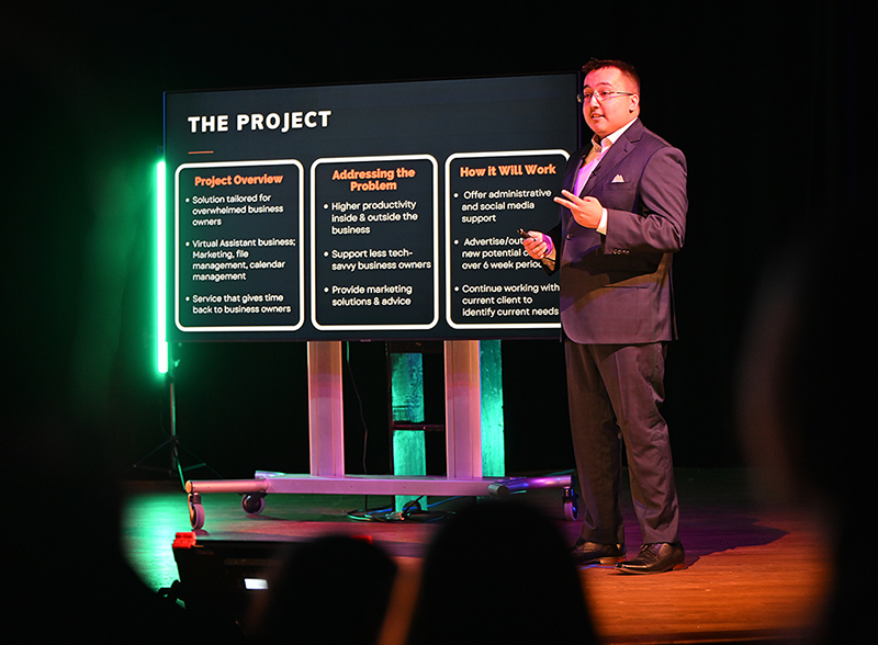 Photo of Bryan Herrera presenting on stage