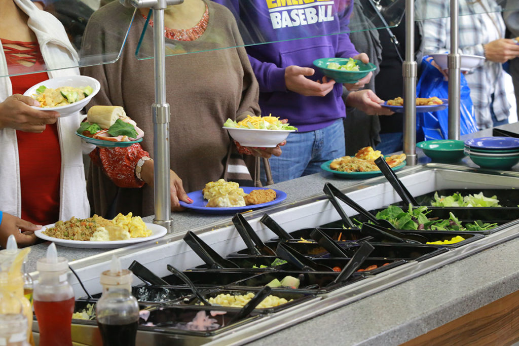 Students with plates of food at counter