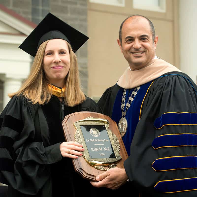 Kelly Neil receiving award from President Cochran