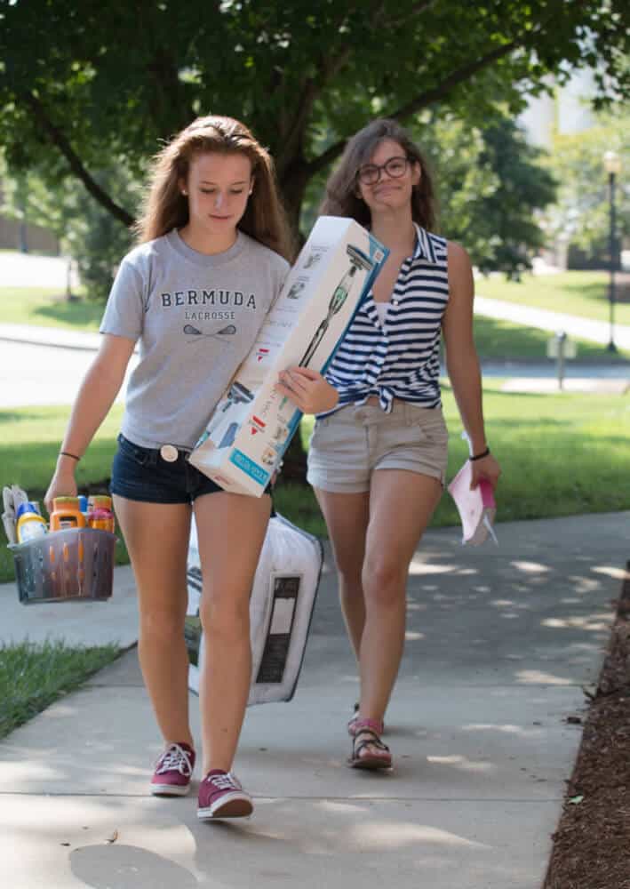 Student carrying belongings into dorm