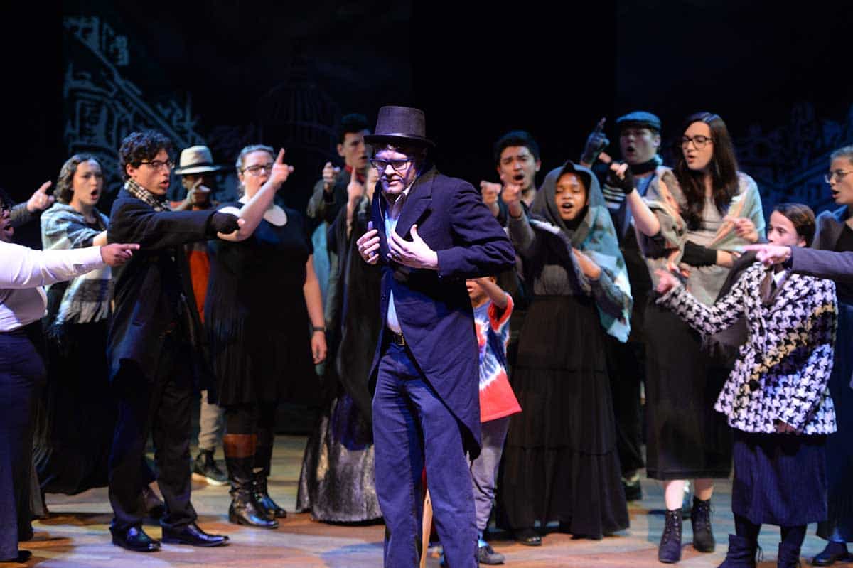 Large group of students on stage preforming the play Mr. Scrooge