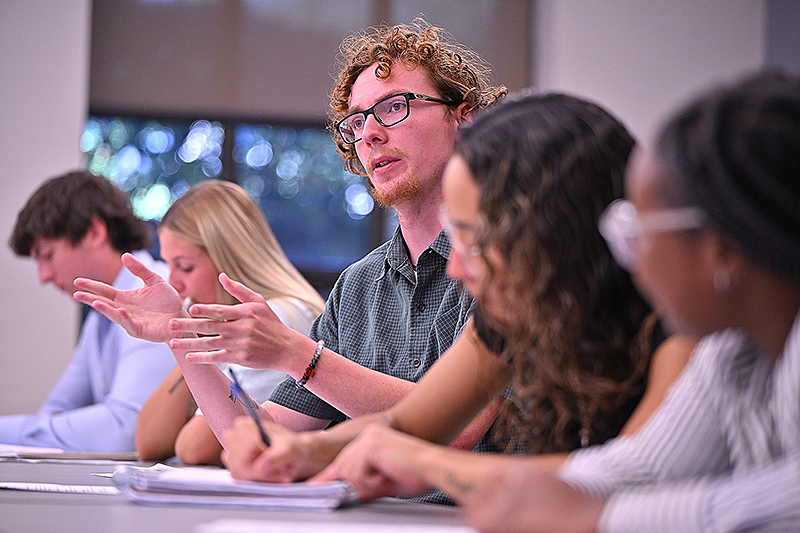 Photo of a student making a point during class.