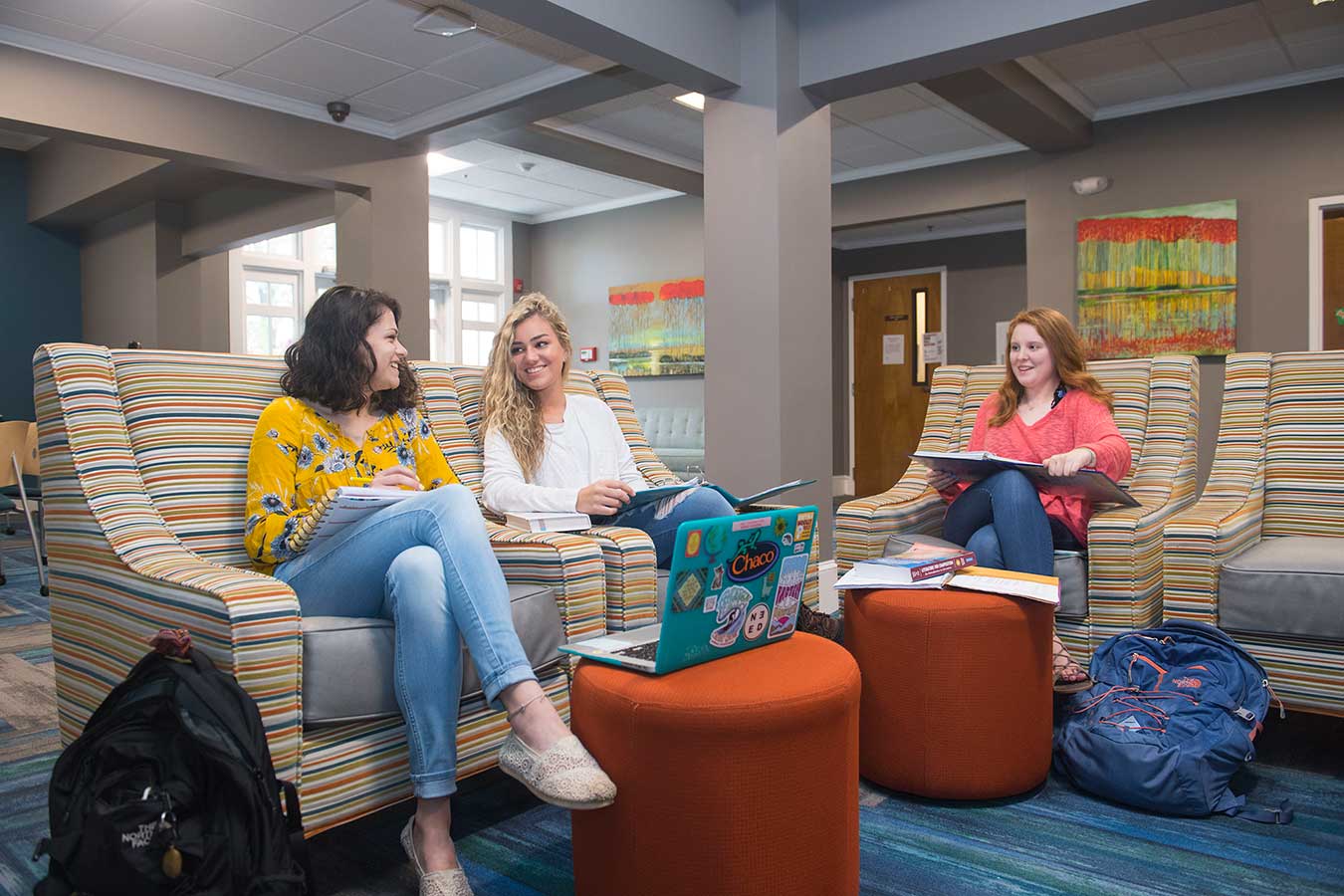 Three woman sitting in residence hall lobby