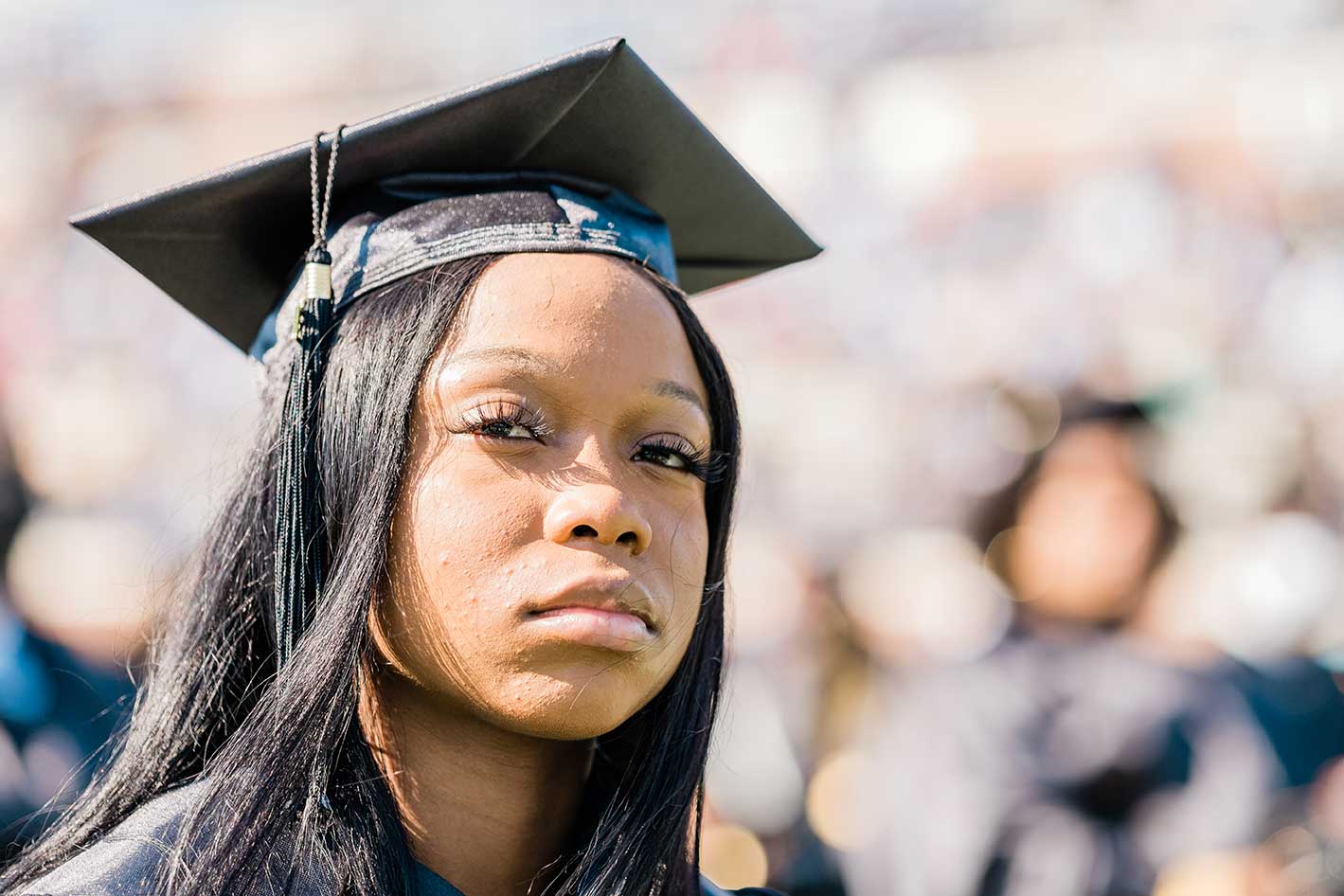 Woman in graduation cap looking ahead