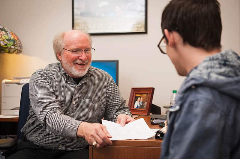 Lanny Lanford talking to student in his office